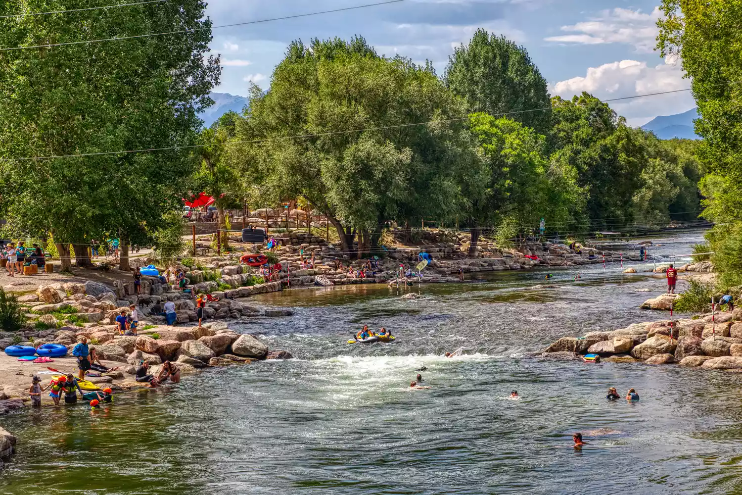 People swimming and relaxing by the riverfront park in Salida, Colorado.