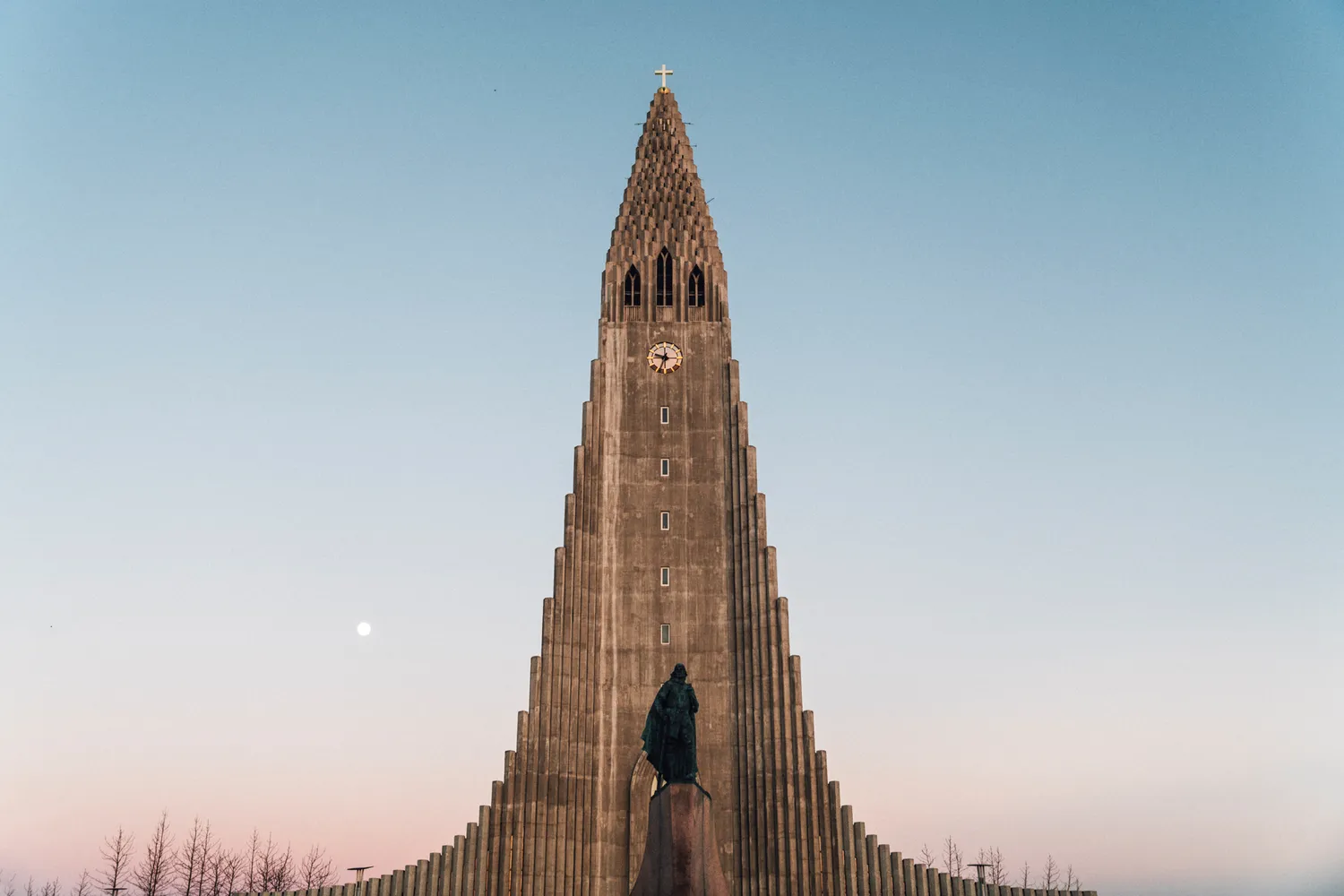 The towering white facade of Hallgrimskirkja church against a blue sky in Reykjavik.
