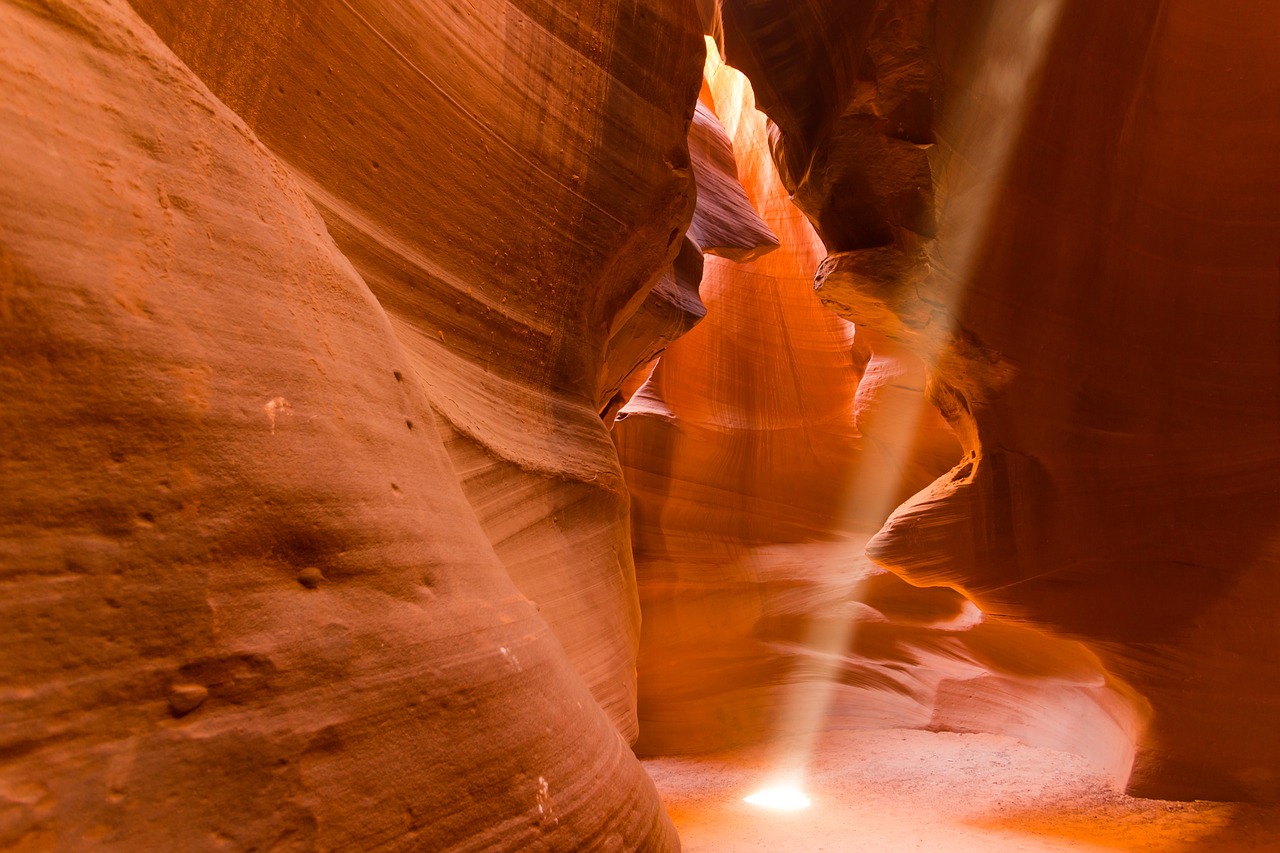 Golden light beams illuminating the smooth, flowing walls of Antelope Canyon, Arizona.