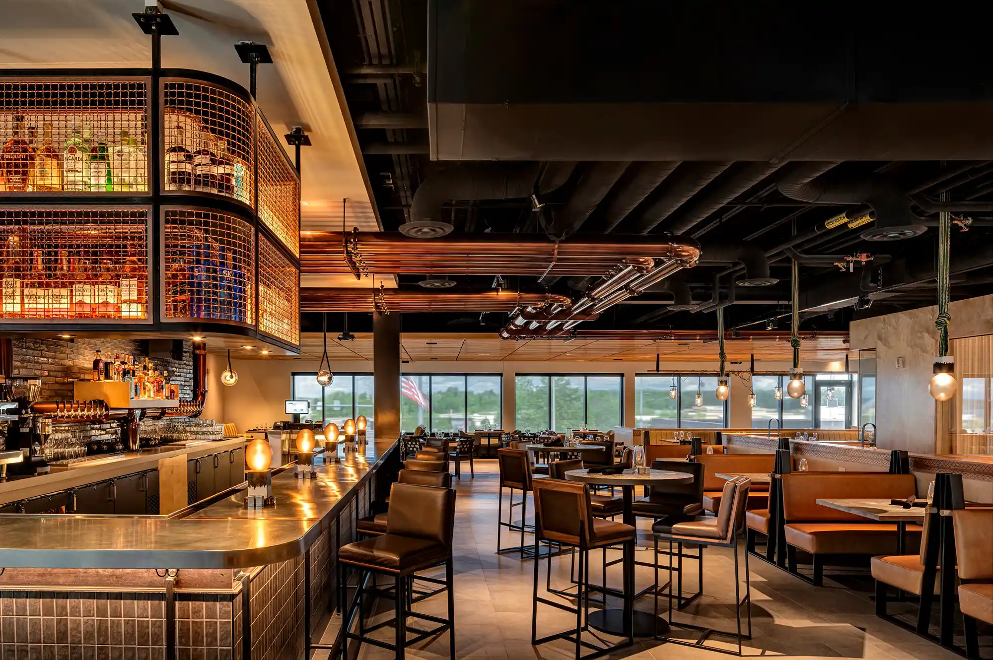 Interior of Crimson restaurant featuring a stylish bar, comfortable booths, and large windows.