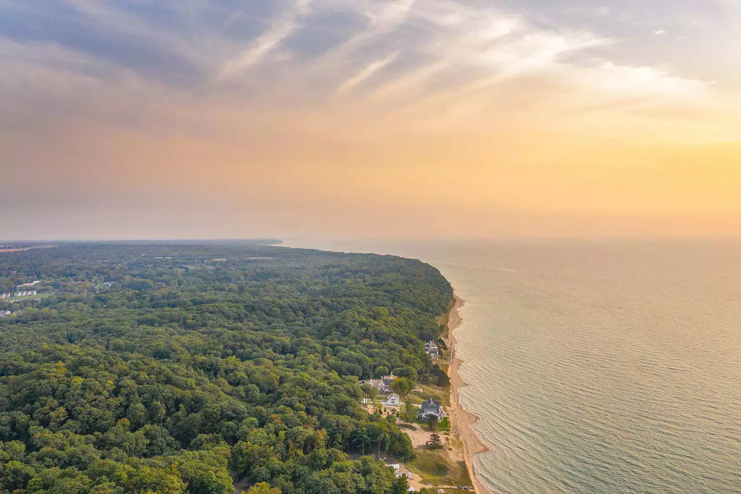 High-altitude aerial view of the Saugatuck coastline and sandy beaches at sunrise.