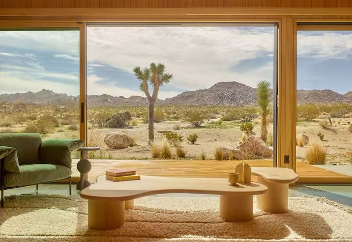 Mid-century modern living room with high-end furniture and panoramic architectural views.