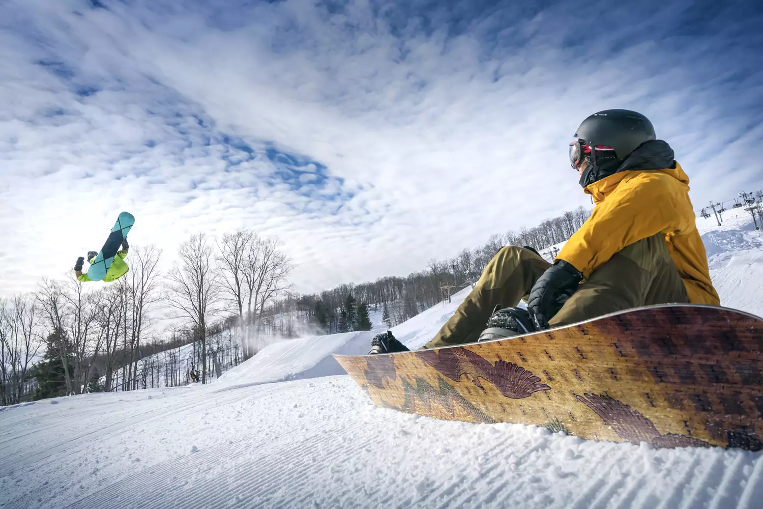 Two snowboarders standing on a snowy ridge at The Highlands at Harbor Springs.