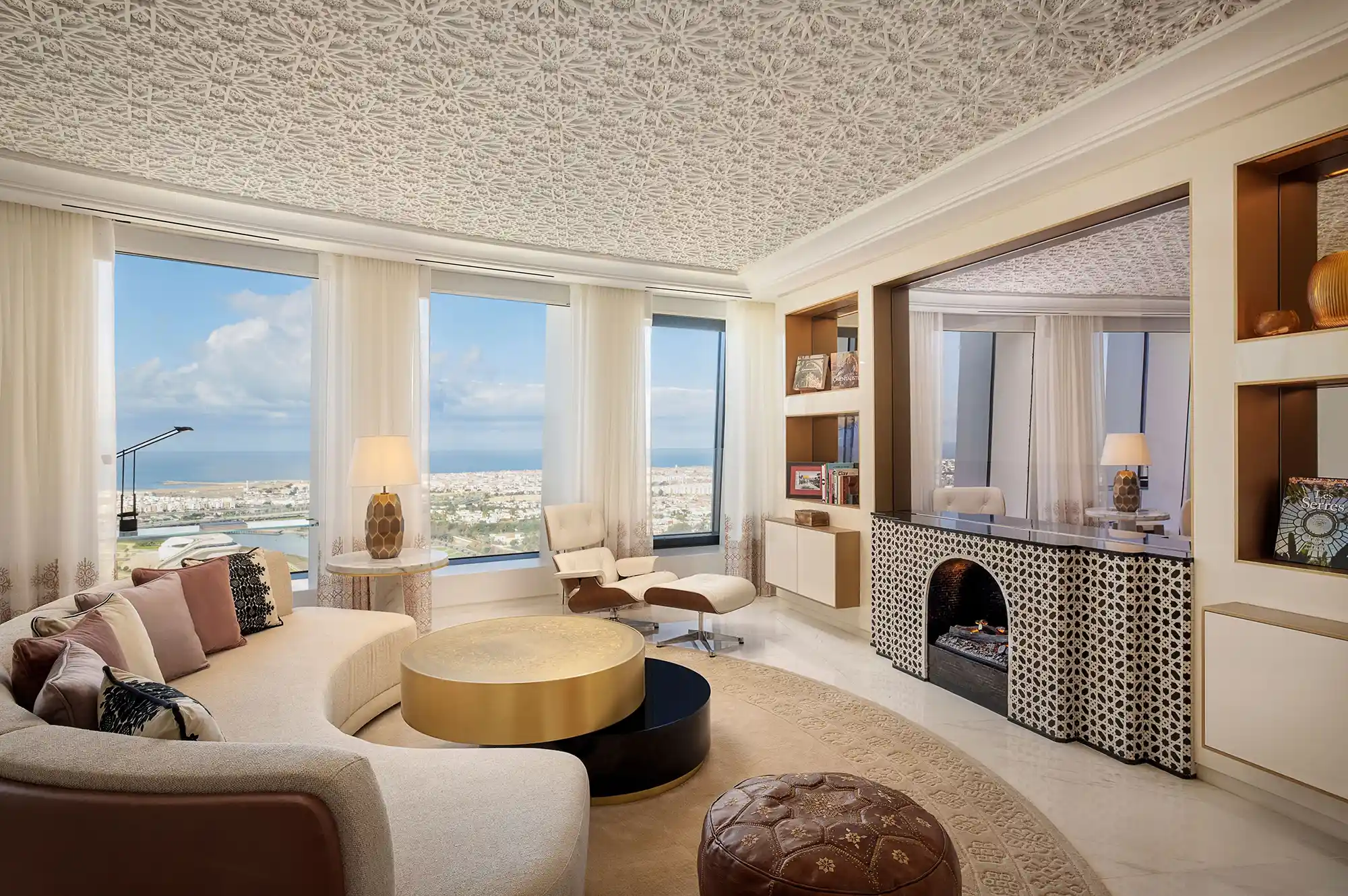 Elegant modern living room with curved designer furniture and floor-to-ceiling windows overlooking the city.