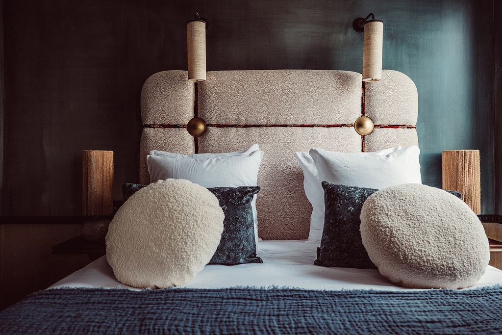 Warm, souk-inspired boutique hotel lounge with glass lanterns and tapestry chairs.