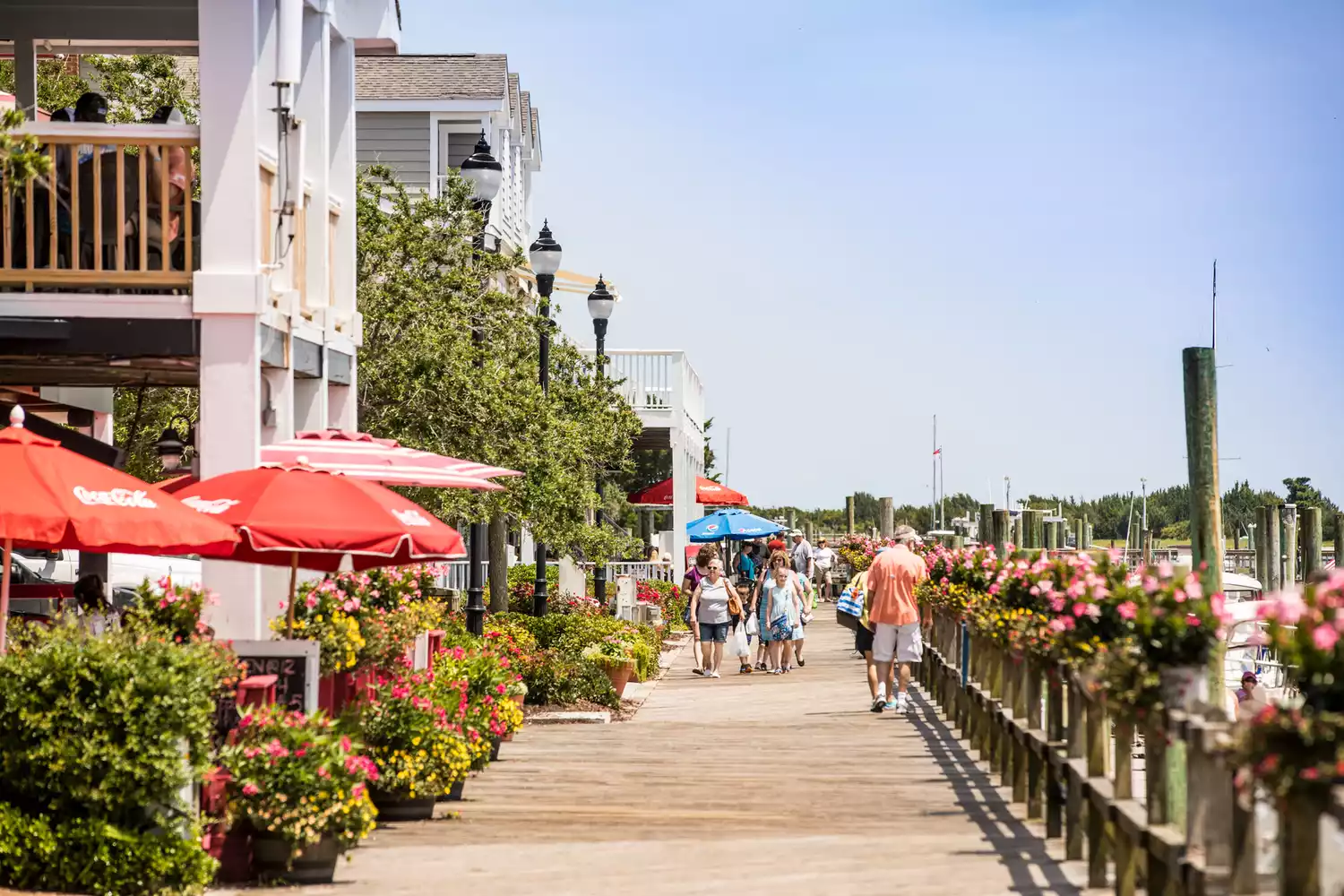 Crowds walking along the sunny waterfront boardwalk in historic downtown Beaufort.