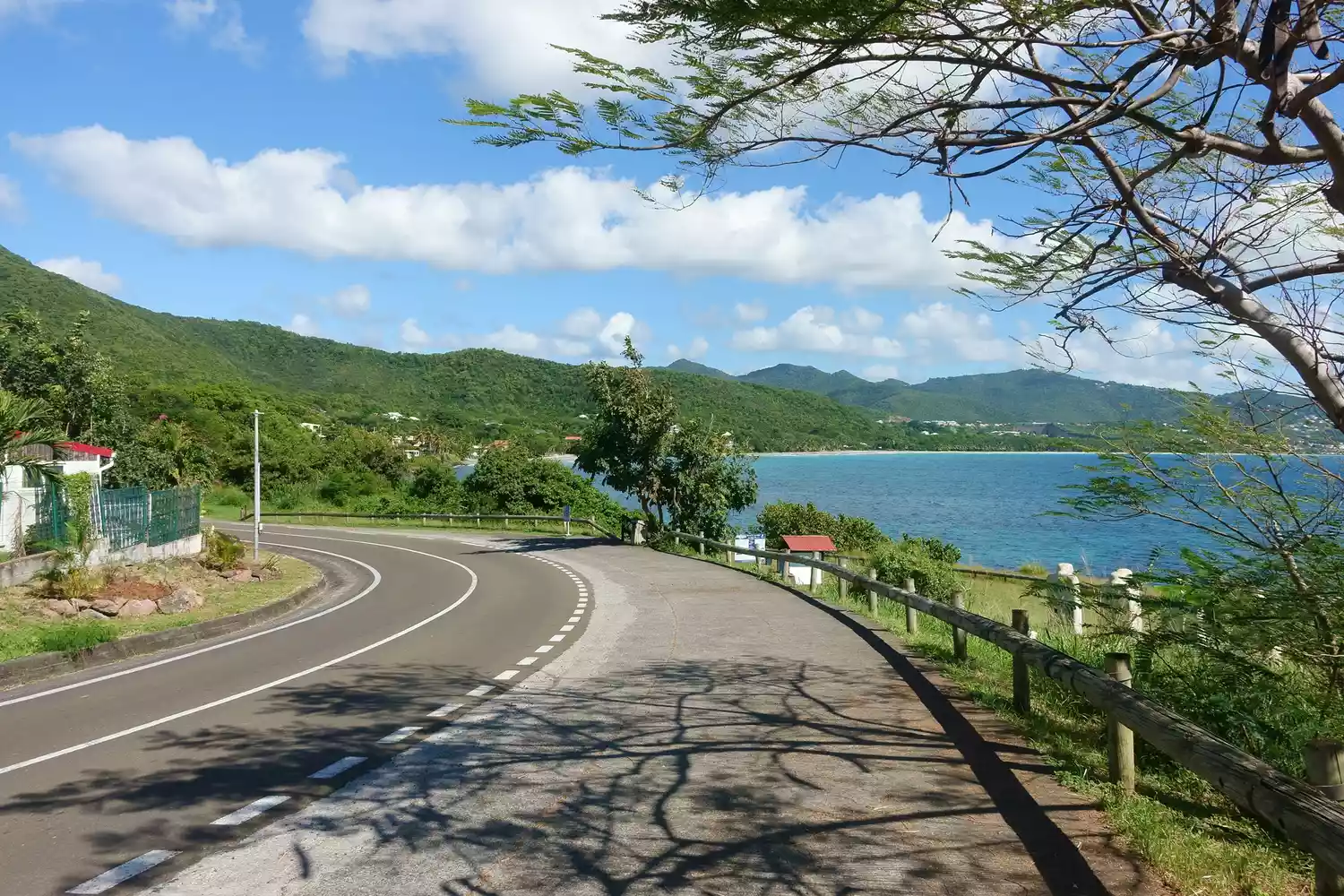 A winding coastal road leading towards the iconic Diamond Rock in Martinique.