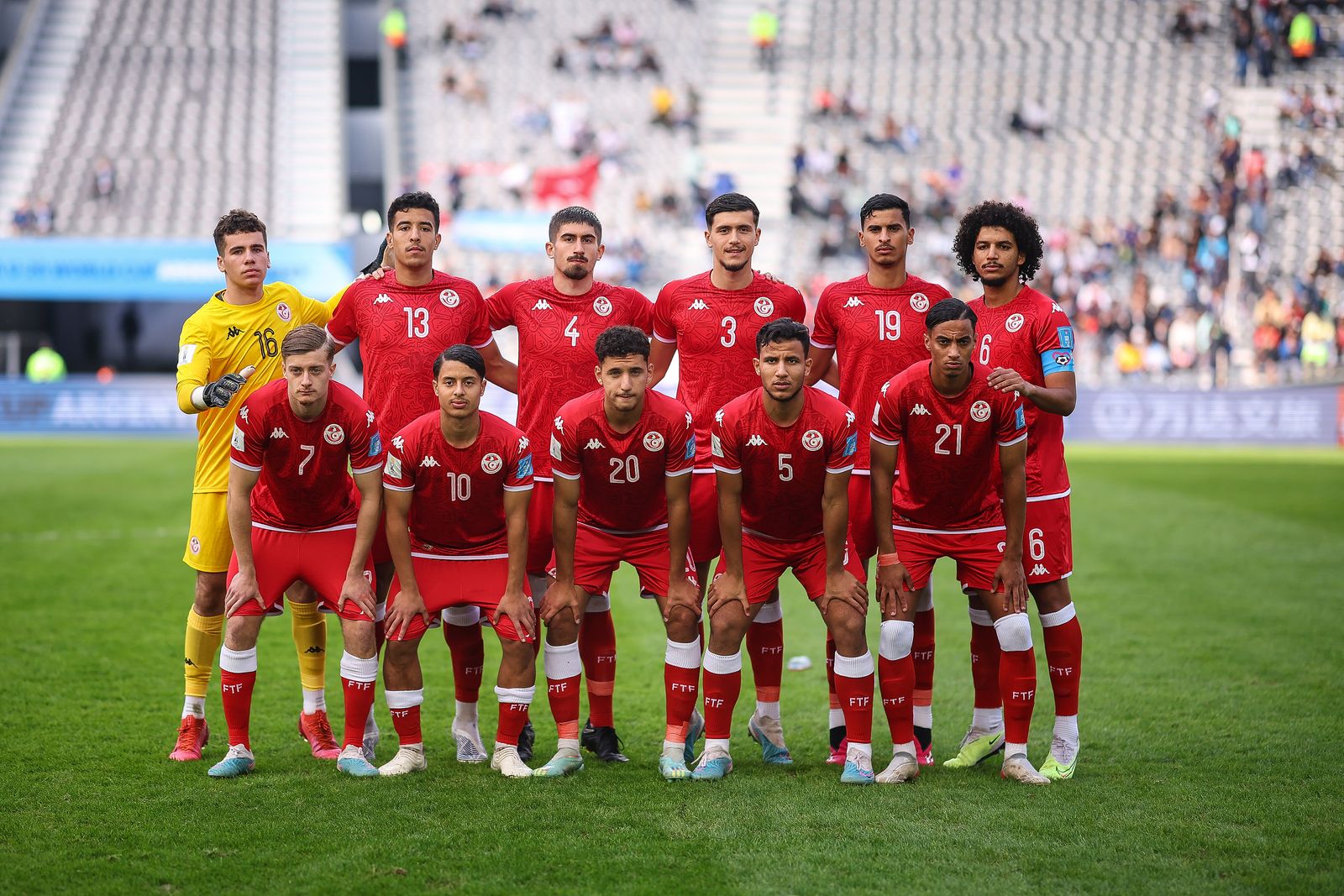 Professional football players from international teams on the field during a match.