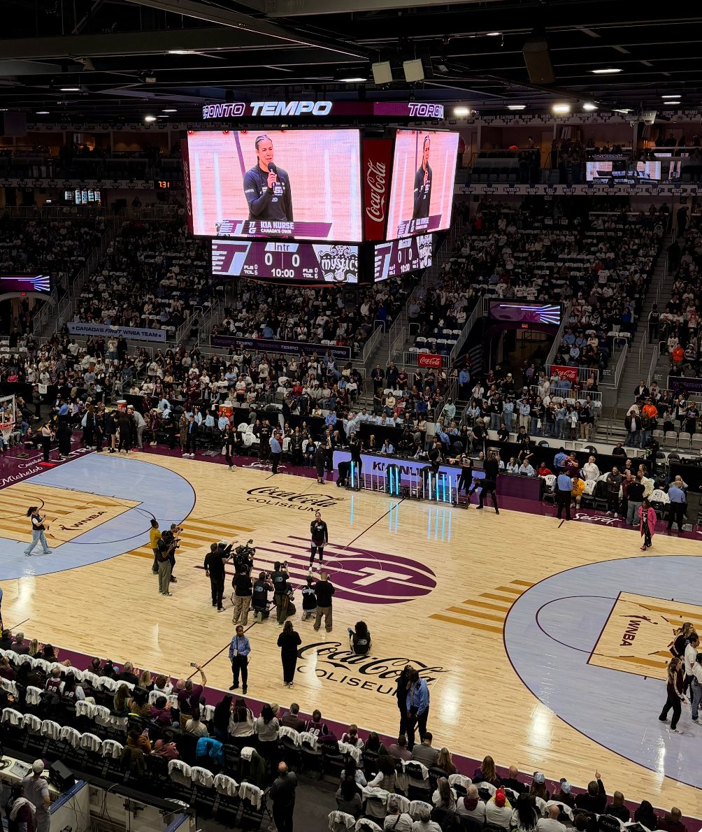 Professional basketball game action in a stadium with spectators.