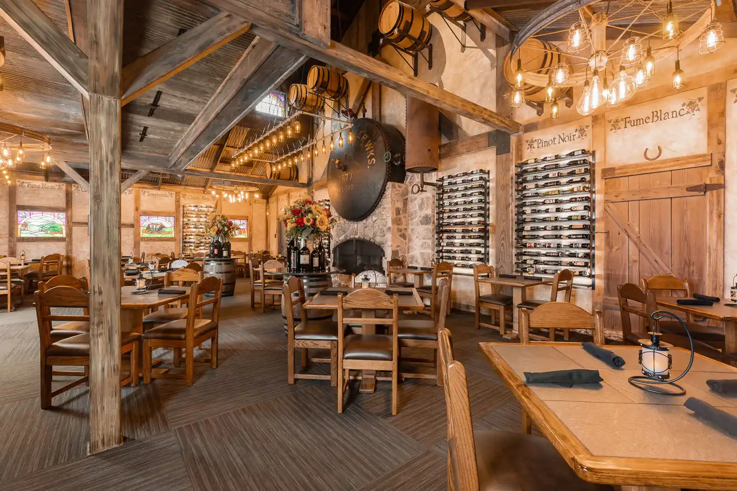 The interior of Cabernet Grill featuring rustic wooden furniture and an extensive wall-mounted wine rack.