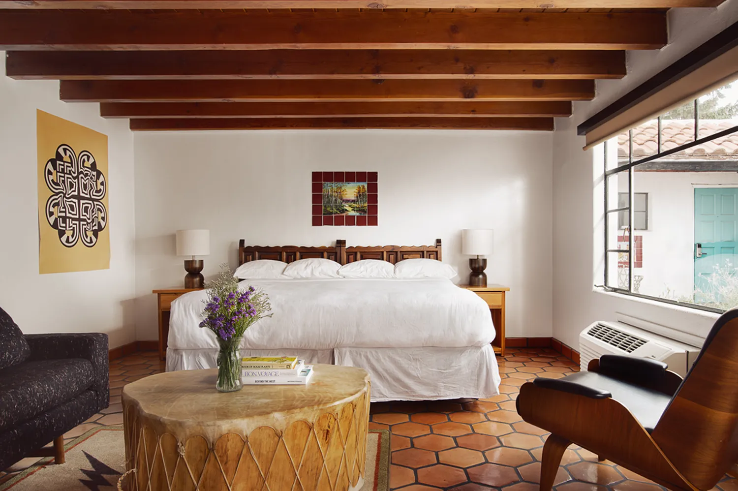 Interior of a boutique hotel room at El Rey Court in Santa Fe with adobe-style beams and minimalist decor.