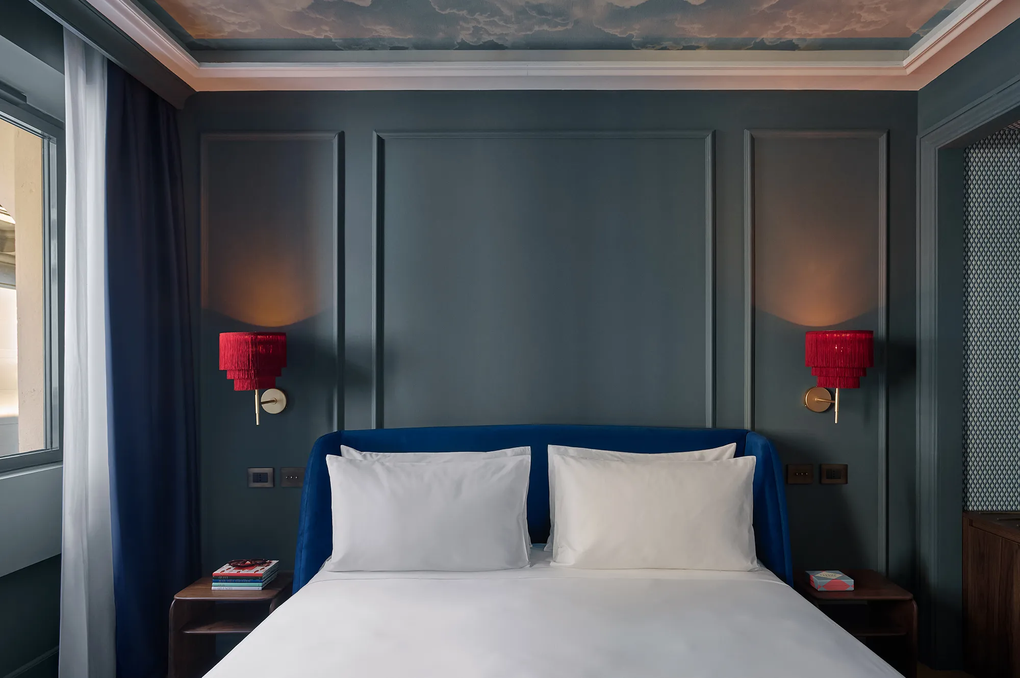 A luxury bedroom at Casa Laveni with a king-sized bed, symmetrical lighting, and elegant minimalist styling.