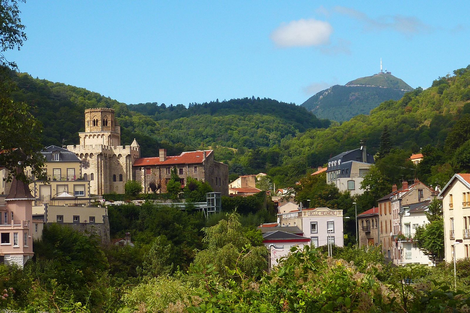 A peaceful rural village with stone buildings nestled in the green hills of the French countryside.