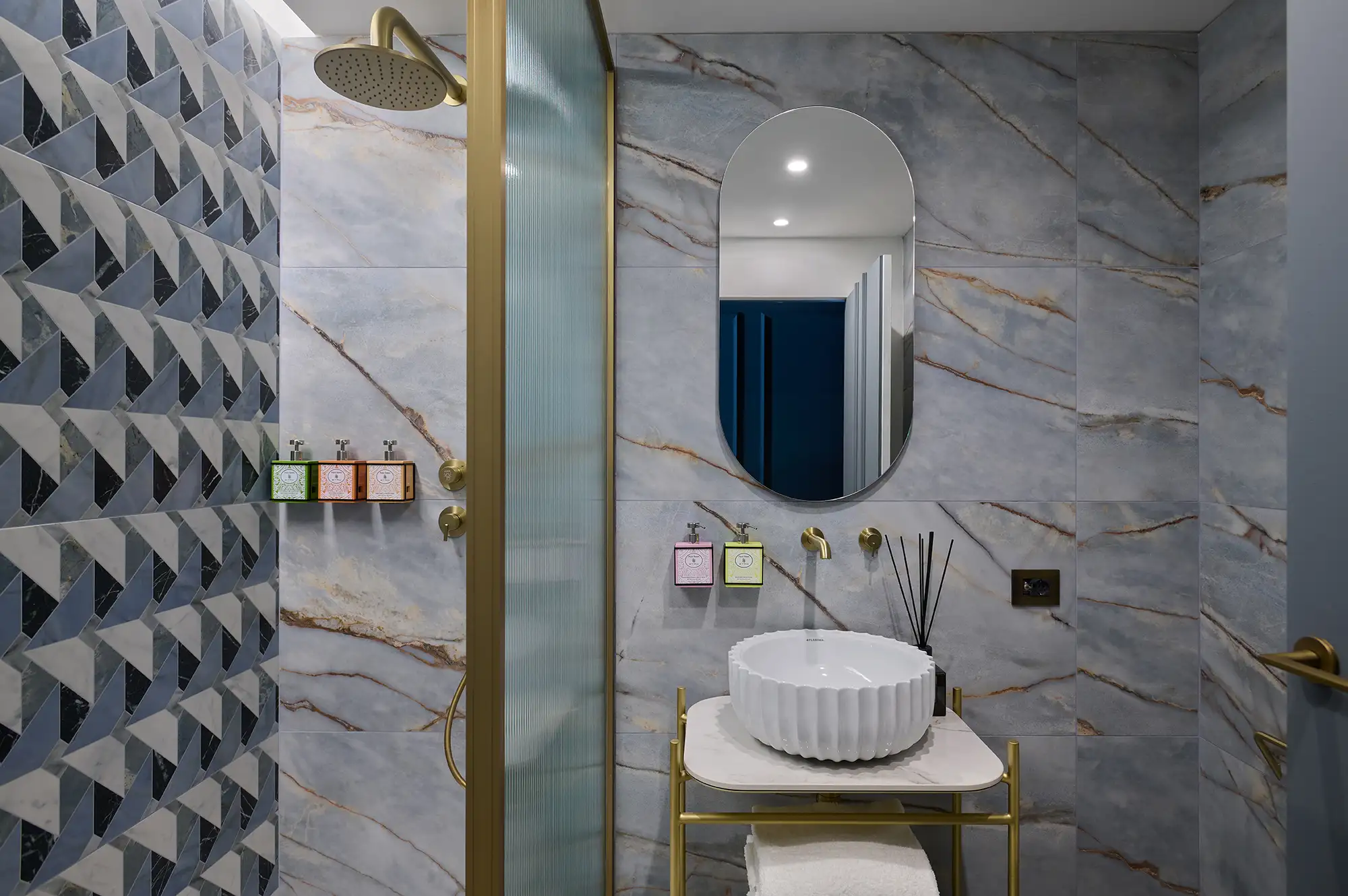 Luxury modern bathroom in a Milan boutique hotel featuring marble walls and a minimalist standing sink.
