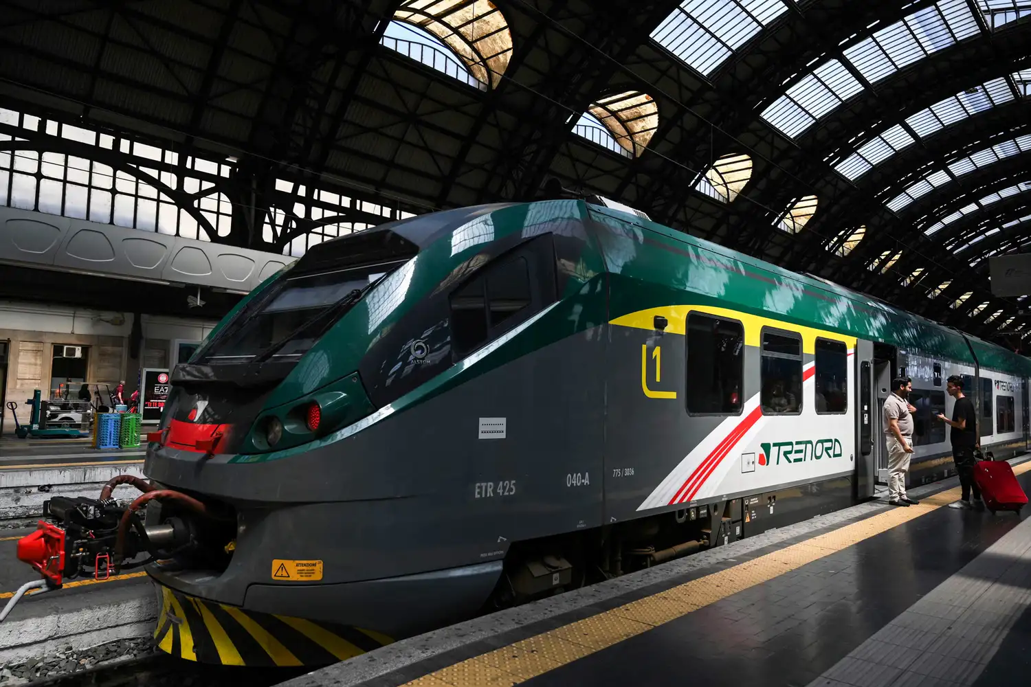 A Trenord regional train at a station platform in Milan.