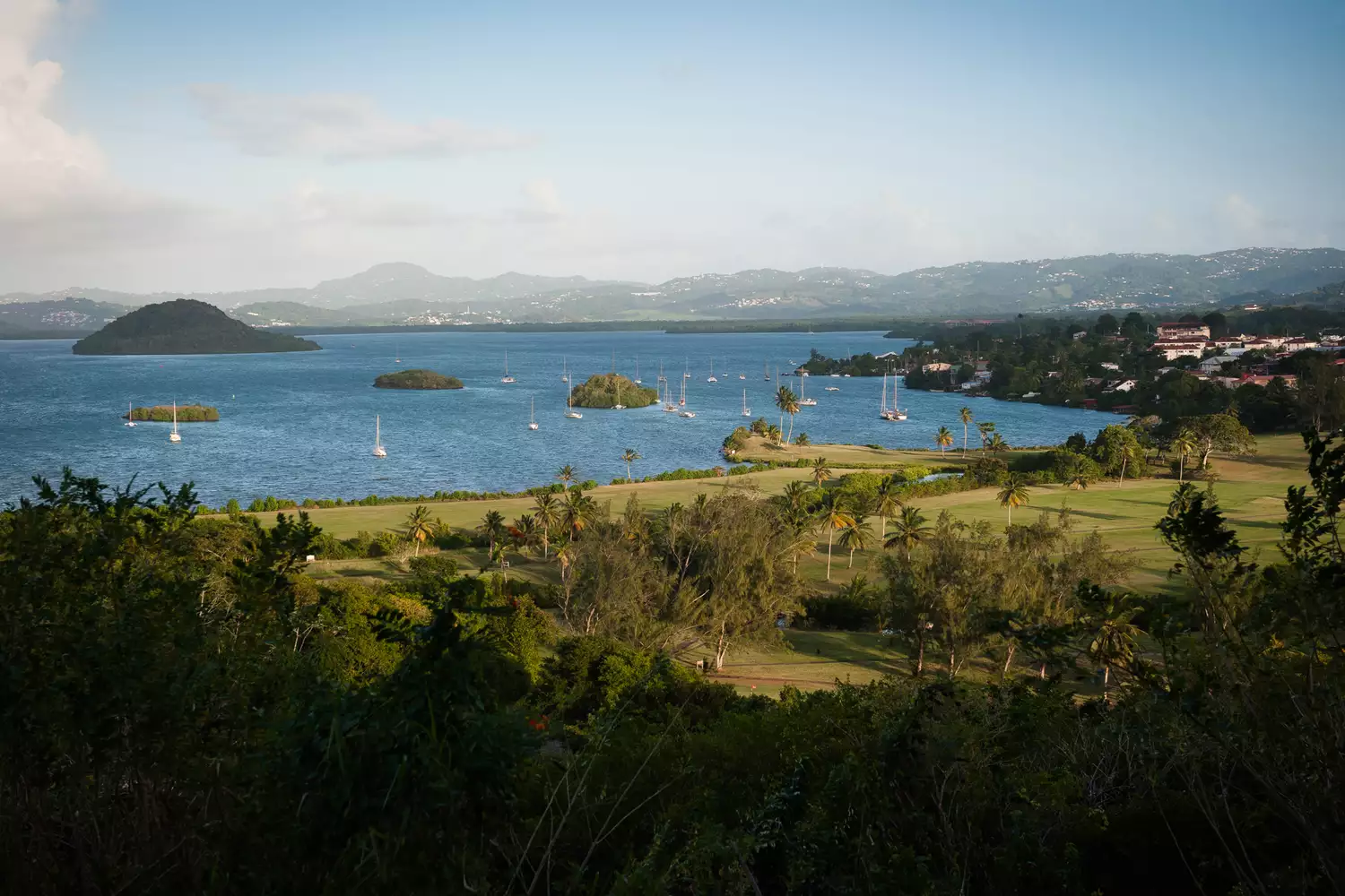 Sunset colors reflecting over the hills and village of Trois Ilets.