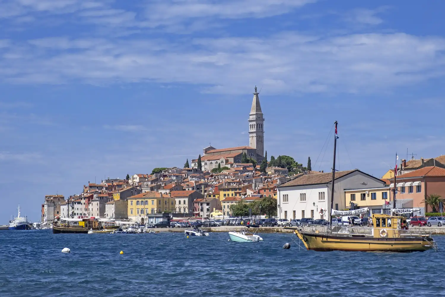 Aerial view of the historic peninsula of Rovinj, Croatia, surrounded by turquoise waters.