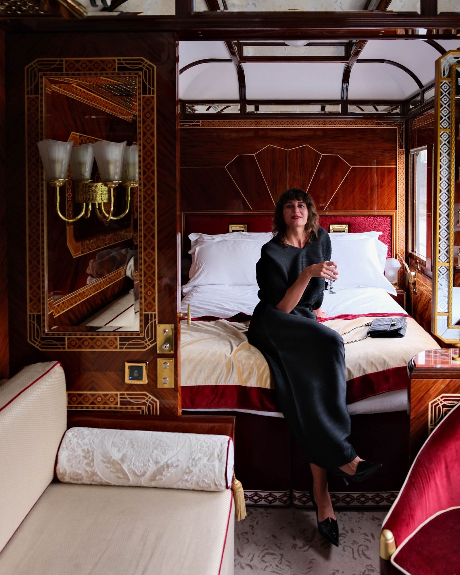 A lavishly decorated Grand Suite bedroom featuring a canopy bed and intricate wood carvings.