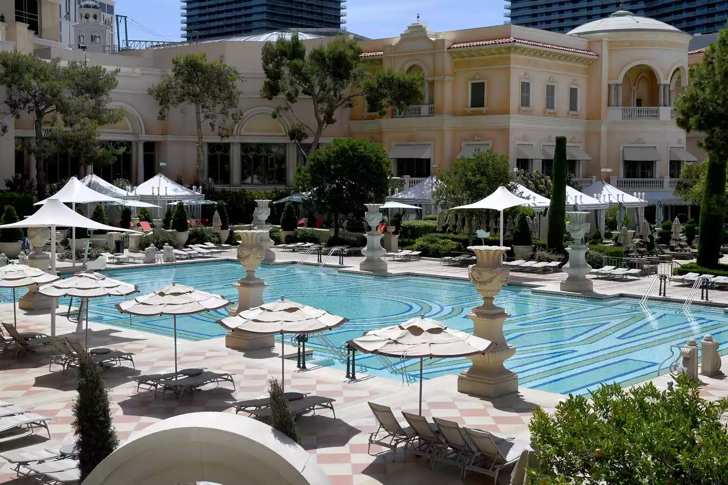 Organized rows of lounge chairs and umbrellas at the Bellagio resort pool.