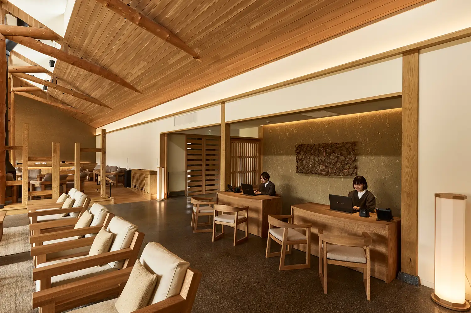 Interior of the hotel lobby with clean wooden lines and minimalist reception desks.