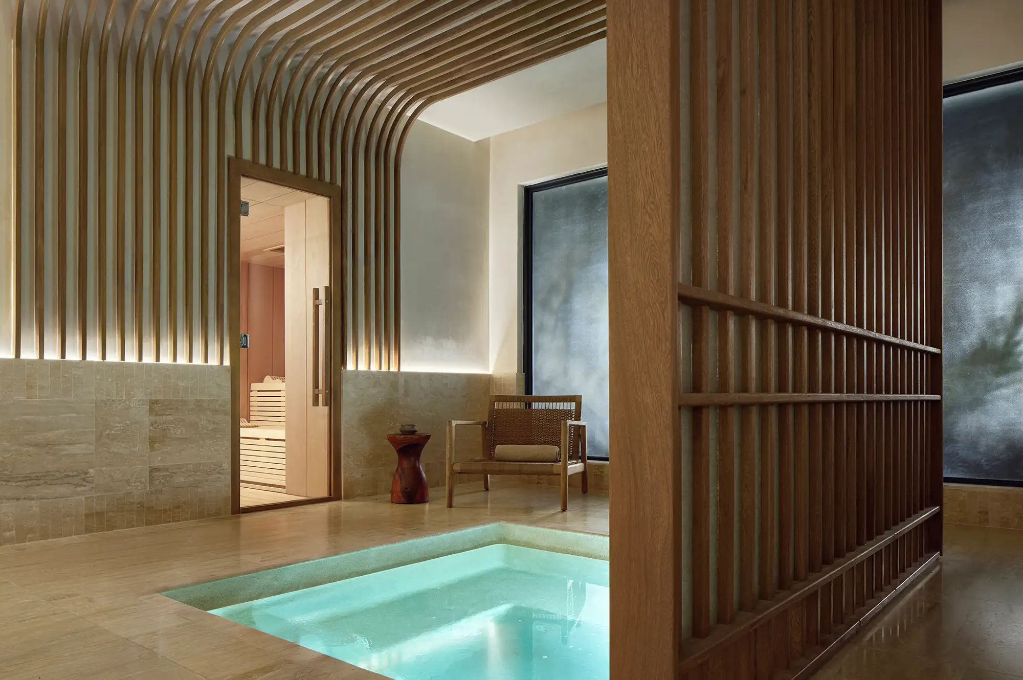 Spa interior with a pool wooden accents and chairs serene atmosphere.