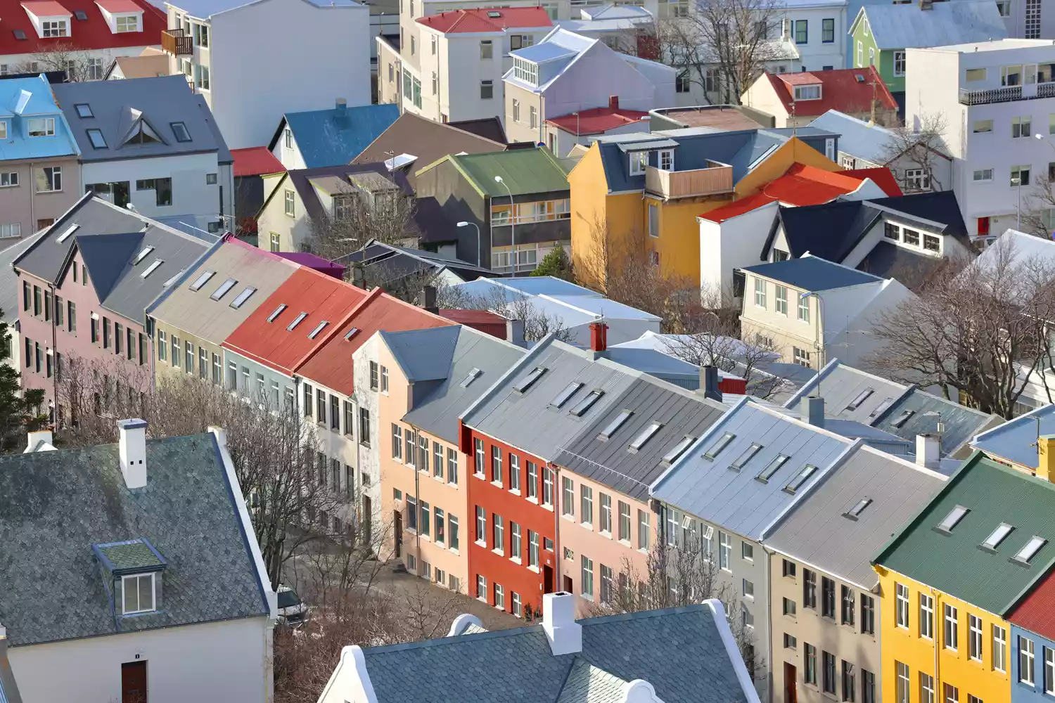 Rows of colorful Nordic buildings in downtown Reykjavik, Iceland under a clear sky.