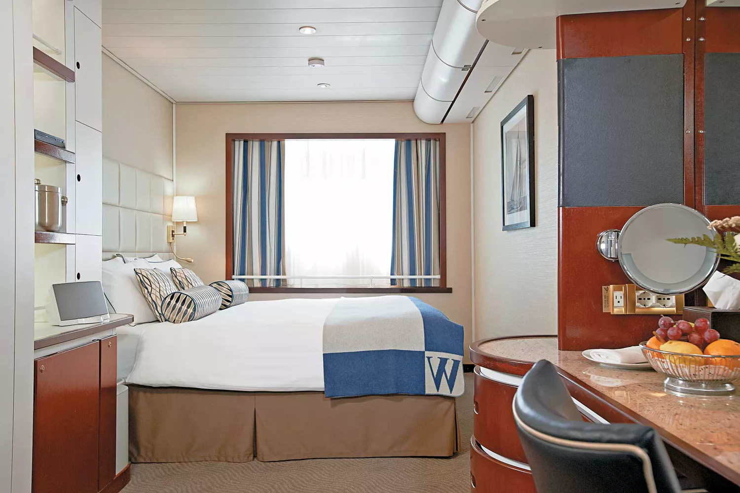 A spacious and elegantly appointed stateroom on Windstar's Wind Surf, featuring a large bed and luxury linens.