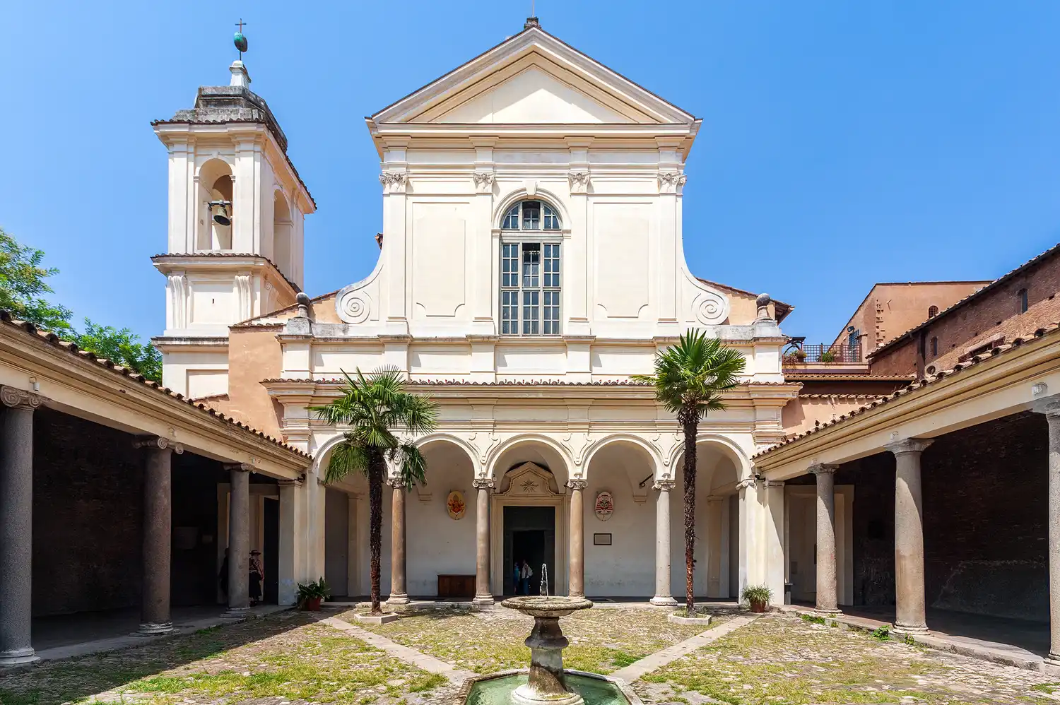 A peaceful courtyard and fountain at the entrance of the Basilica of San Clemente in Rome.