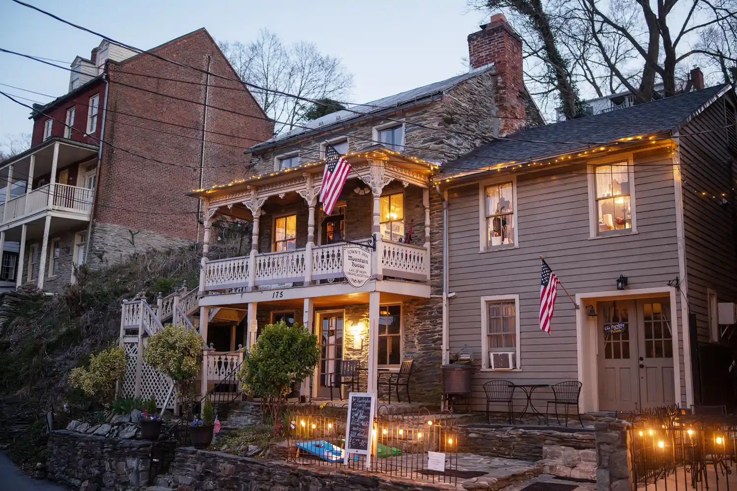 The exterior of the historic Town's Inn decorated with American flags along a sidewalk.