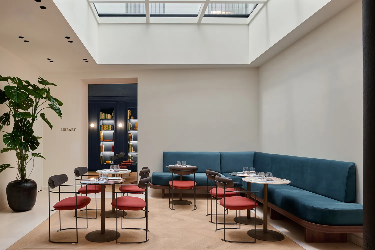 The breakfast room at Casa Laveni featuring modern dining tables, chairs, and an overhead skylight.