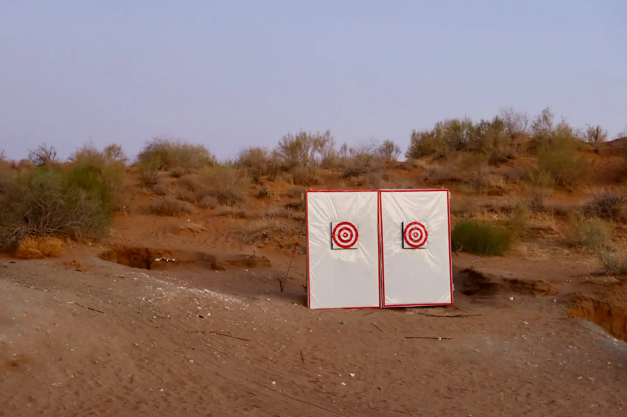 Archery targets standing in the desert sand near the yurt camp.