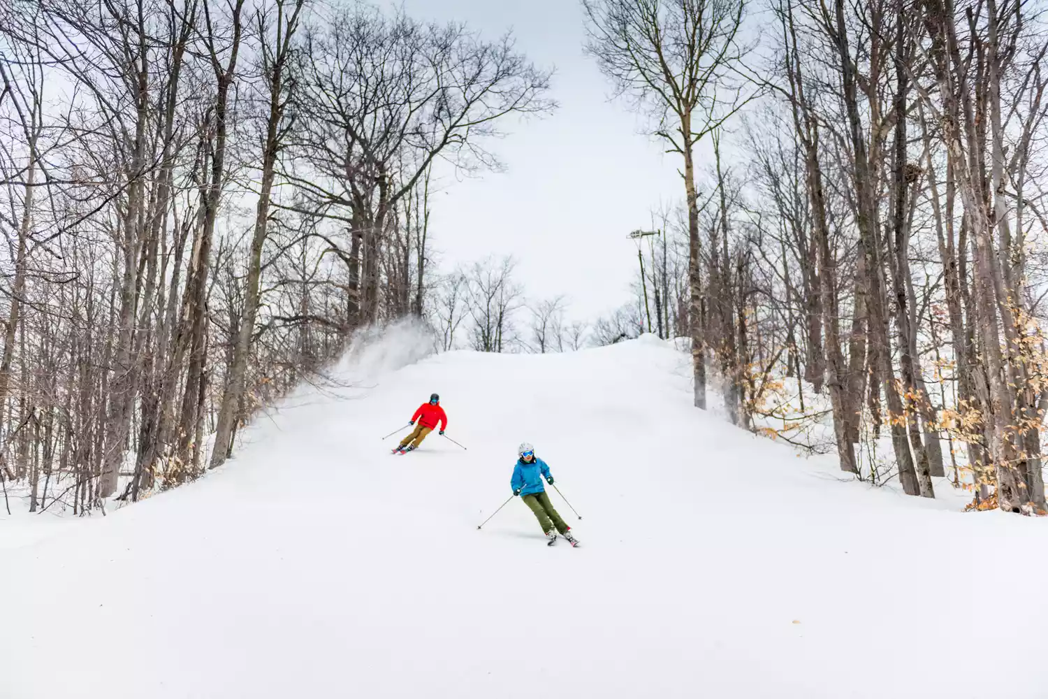A group of skiers gathered at the top of a hill at Shanty Creek Resort.
