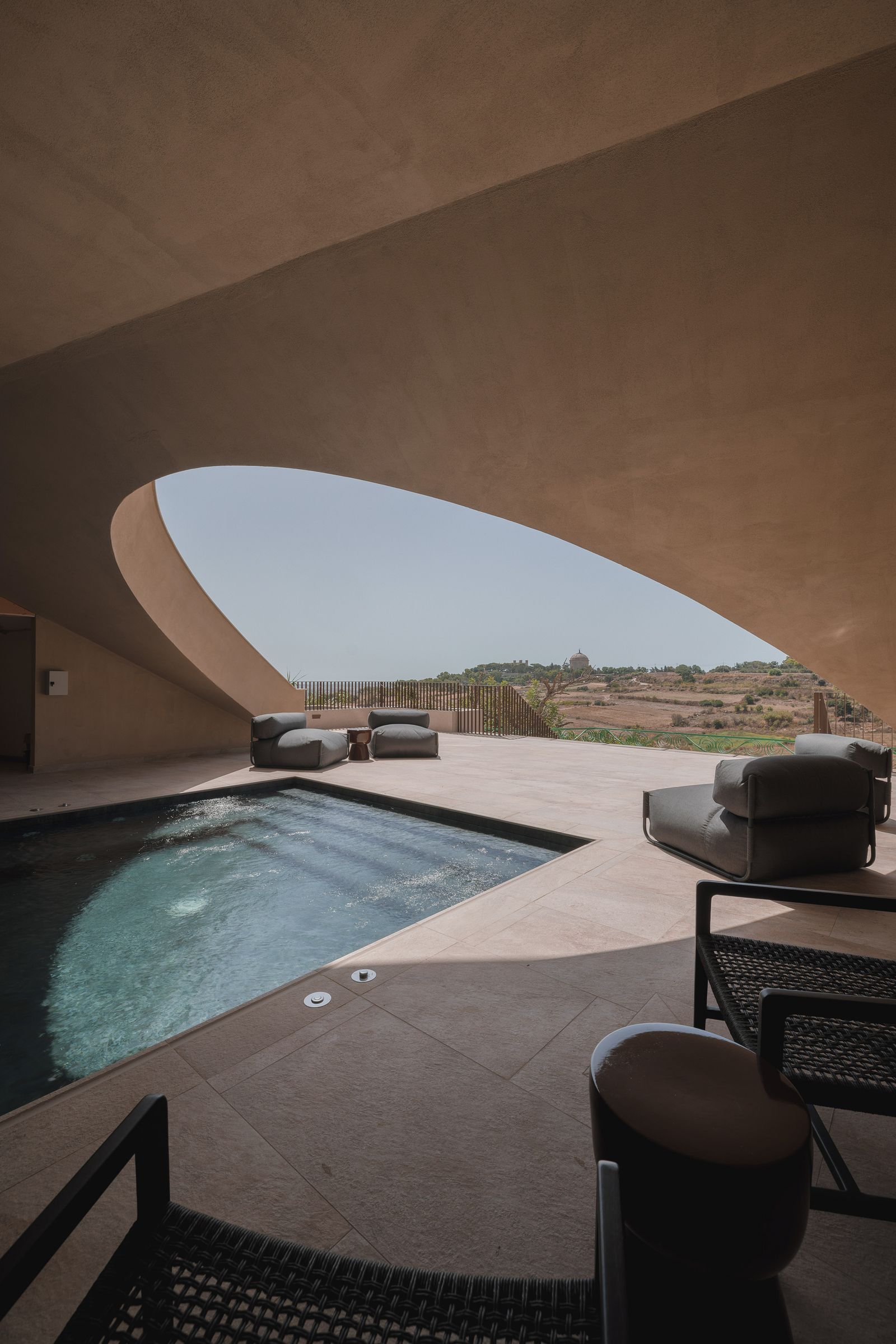 A luxurious indoor swimming pool with architectural lighting and elegant furniture.