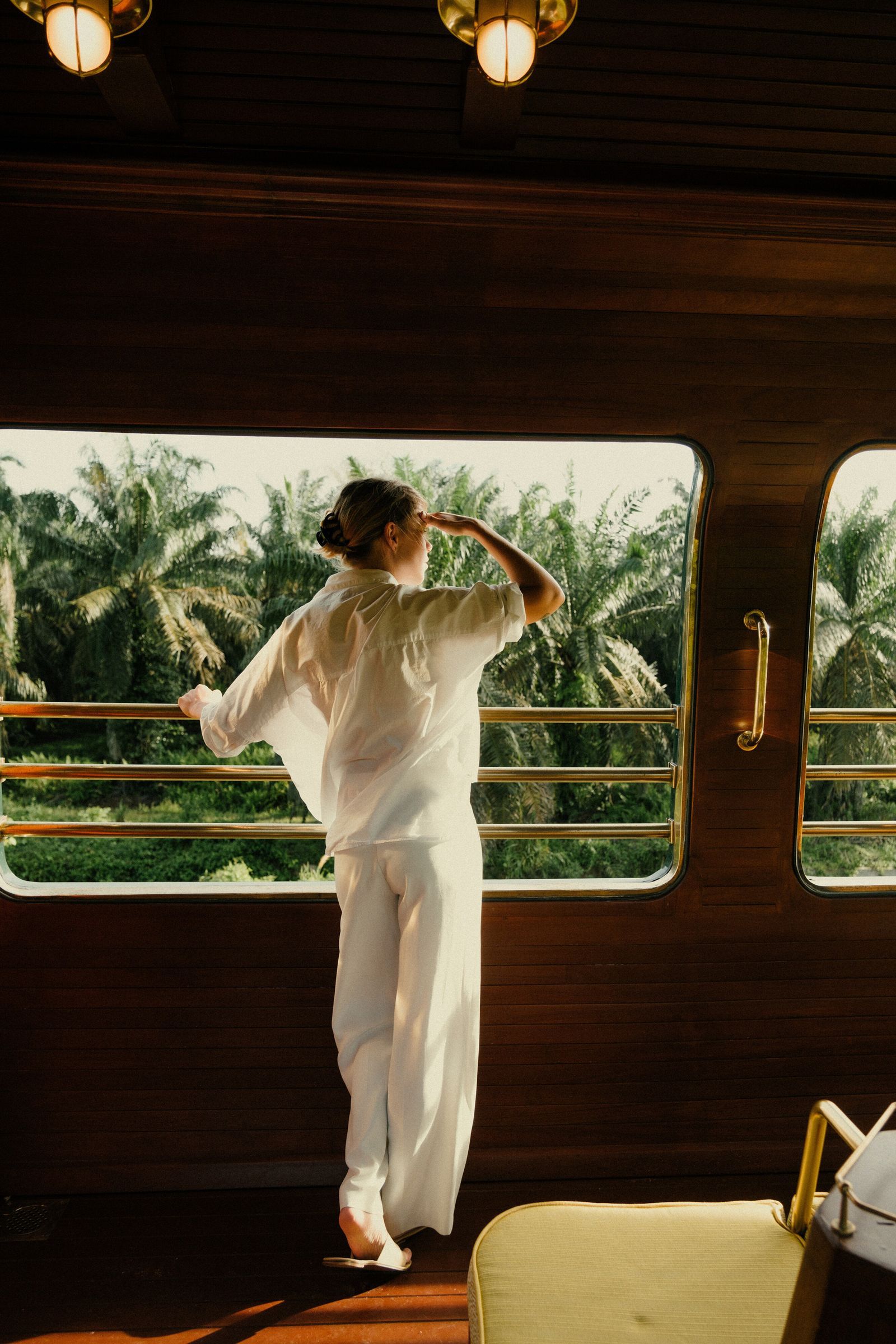 A stylish man in formal wear standing outdoors near palm trees, reflecting a luxury lifestyle.